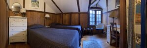 panoramic of blue room with beds and window